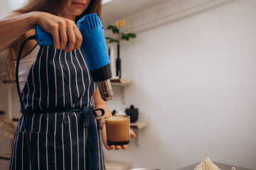 Woman pouring melted wax into amber candles container. Ecological and vegan business. Soya wax candle accessories. Handmade with love.