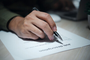 Job Description document with Pen on the table.