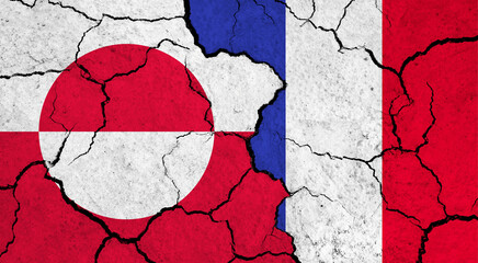 Flags of Greenland and France on cracked surface - politics, relationship concept