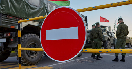 Soldiers stand near the car against the background of the STOP sign.