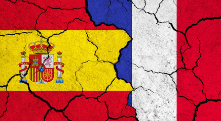 Flags of Spain and France on cracked surface - politics, relationship concept