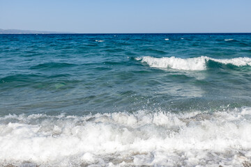 a white waves in the blue sea on the beach