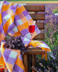 Picnic in the lavender field. A glass of wine, a blanket, a bouquet of lavender. Relax in nature