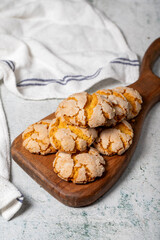 Orange cookies. Cracked delicious cookies on wood serving board