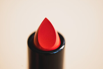 open red lipstick on a beige background