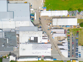 Aerial view of goods warehouse. Logistics center in industrial city zone from above. Aerial view of trucks loading at logistic center