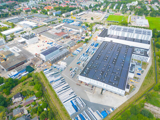 Aerial view of modern storage warehouse with solar panels on the roof. Logistics center in...