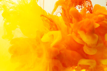 Close up of yellow and orange ink in water with copy space on white background