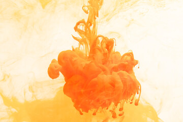 Close up of orange and yellow ink in water with copy space on white background