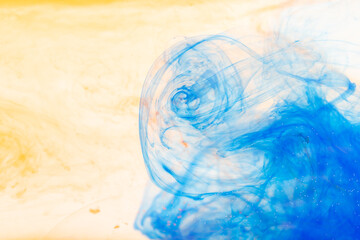 Close up of yellow and blue ink in water with copy space background