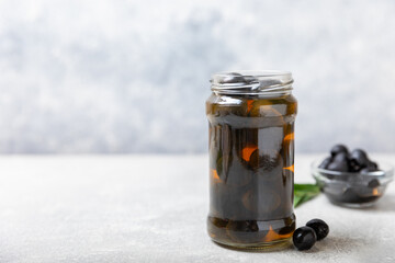 Delicious black olives. Pickled olives in glass jar. On a wooden background.Tasty olives. Close-up. Vegan.Place for text. copy space.