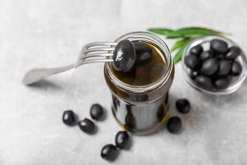 Delicious black olives. Pickled olives in glass jar. On a wooden background.Tasty olives. Close-up. Vegan.Place for text. copy space.