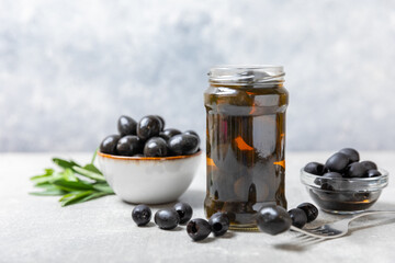 Delicious black olives. Pickled olives in glass jar. On a wooden background.Tasty olives. Close-up. Vegan.Place for text. copy space.