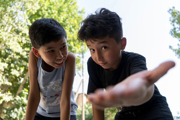 best friends in Uzbekistan enjoying there summer vacation in an outdoor park  playing games and the different expressions on their faces while playing in hot street make a friendship day special 
