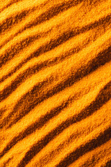 Close up of pattern of orange sand and copy space background