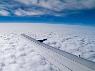 Fototapeta premium airplane over the clouds one wing in picture