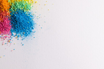 Close up of multi coloured sand and copy space on white background