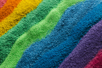 Close up of stripes of rainbow coloured sand and copy space background