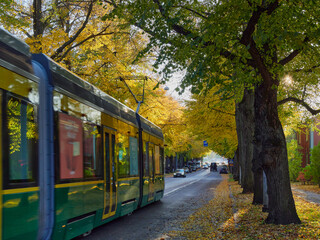 Tram in European city in autumn: wooden historic houses in Helsinki, Kapyla.