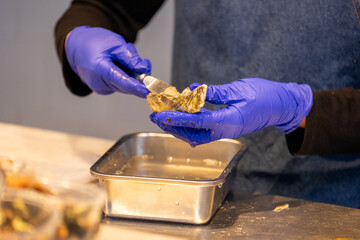 Cleaning a sea urchin and oysters at a food market