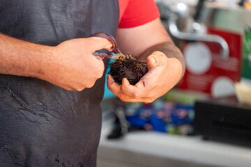 Cleaning a sea urchin and oysters at a food market