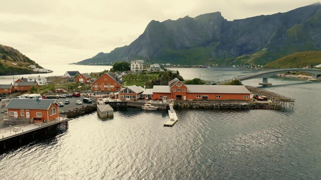 Drone flies over red rorbu houses in the fishing village Hamnoy on the Lofoten islands.