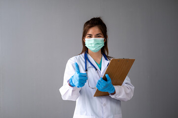 Female nurse doctor with a mask putting on medical gloves, woman doctor in white uniform wearing mask and rubber gloves