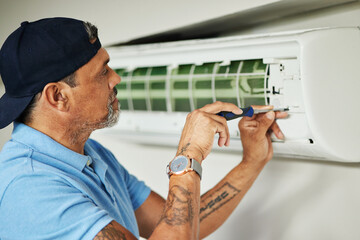 Electrician, maintenance and air conditioning with man and screwdriver for ac repair, ventilation...