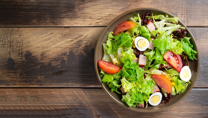 Fresh healthy salad on wooden table. View from above with copy space