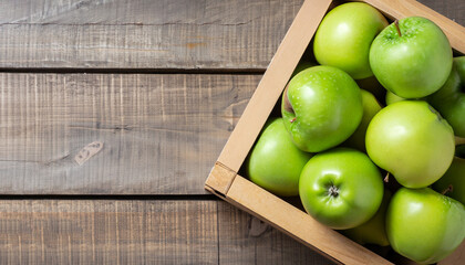 Ripe green apples box on wooden table. Top view with space for your text