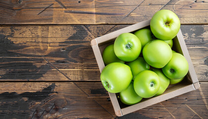 Ripe green apples box on wooden table. Top view with space for your text