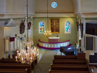 Interior of building of old Lutheran church at old cemetery in Finnish Tuusula town: basket with children's toys on bench.