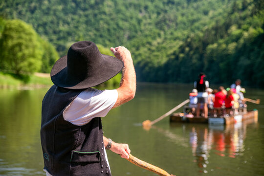 Old rafter rafting river on wooden raft