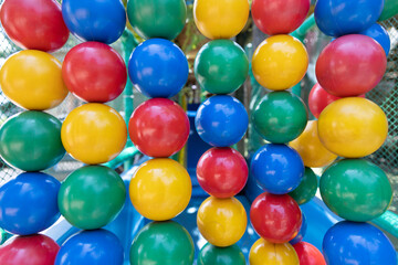Fototapeta na wymiar colored balls in a continuous series, which form a colored wall of blue, red, green and yellow almost forming a rainbow