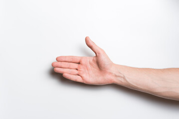 Naklejka premium Close-up of a man's hand. He stretches out his hand for a handshake gesture on a white background.