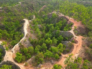 The epic Pai Canyon in Pai, Thailand taken from above from the bird's eye view with the drone surrounded by trees.