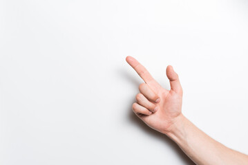 A close-up of a man's hand points with his index finger at a copy space for advertising on a white background.