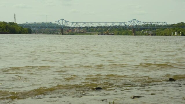 a view of Monaca East Rochester Bridge  in Western Pennsylvania with the muddy calm water of the Ohio river