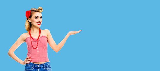 Full body photo - happy excited smiling woman holding, giving, advertising something. Blond girl in...