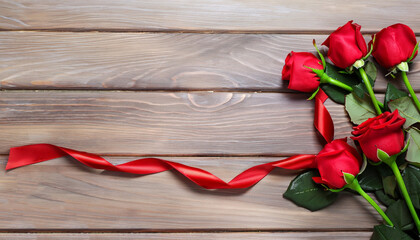 Red roses and heart shape ribbon over wooden table. Valentines day background. Top view with copy space