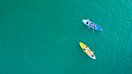 Aerial view of canoe boats in mountain river with turquoise water with rock cliffs. People...
