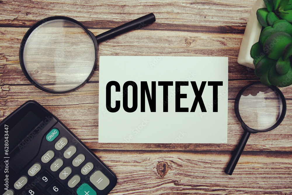 Aufkleber context text message with magnifying glass on wooden background