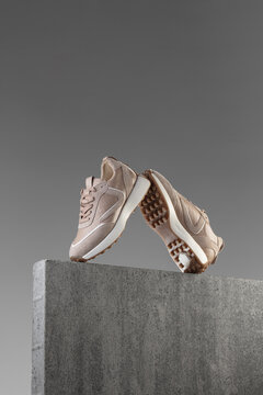 Modern street shoes stand stone on stone against a gray background
