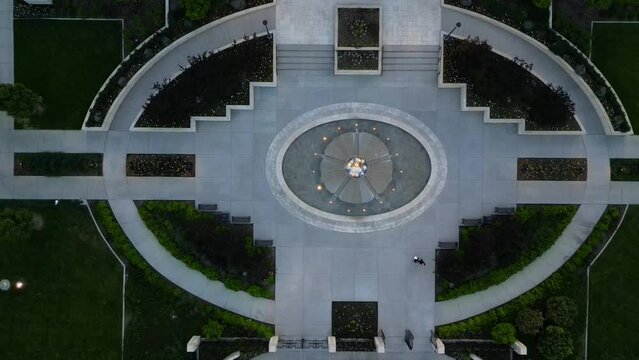 LDS Mormon Temple in Ogden Utah drone flight flying at dusk on beautiful summer night as camera looks down over water fountain feature on temple grounds and zooms in and out.