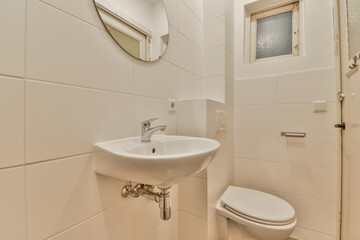 a small bathroom with a sink and toilet paper disped on the wall next to it is a mirror