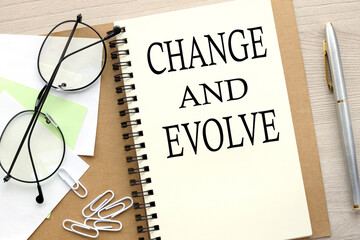CHANGE AND EVOLVE open notebook with stickers and glasses .word on page