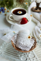 Bright juicy summer still life with cup of coffee or tea, daisies, strawberries, candle in a vintage candle holder and lace ribbon. Light still life with flowers and berries