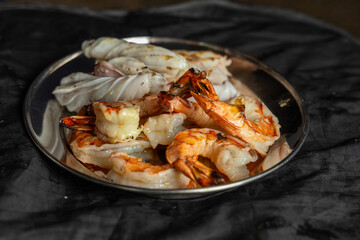 Photo of a delicious seafood dish with fresh shrimp served in a metal bowl