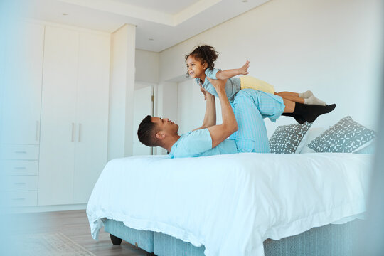 Airplane, bonding and father playing with his child for quality time, fun or happiness at home. Happy, smile and young dad relaxing with his boy kid in a superhero costume on the bed at family house.