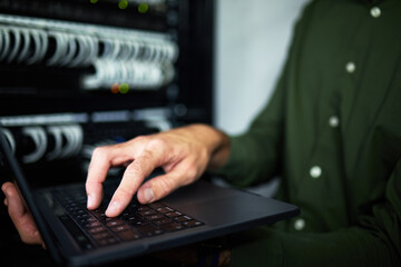 Server room hands, laptop and technician at work for cyber security and building network. Programming, coding and a person or it worker with a computer for a connection system in the workplace